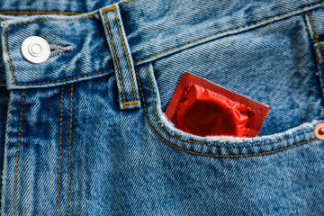 Closeup view of jeans with condom in pocket. Safe sex concept