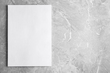 Blank paper sheet on light grey marble background, top view. Mock up for design