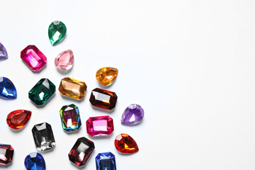 Different beautiful gemstones on white background, top view