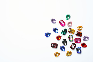 Different beautiful gemstones on white background, top view