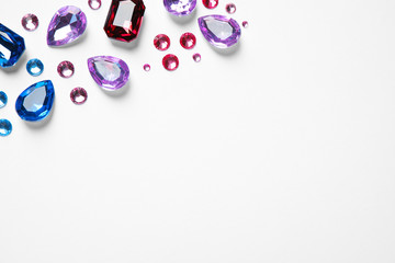 Different beautiful gemstones on white background, top view