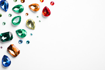 Different beautiful gemstones on white background, top view