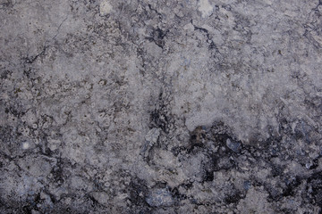 White and grey granite, limestone, or travertine surface with random black organic natural deep bumpy scratch pattern on surface.