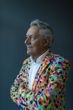 Senior businessman wearing colorful sports jacket looking away