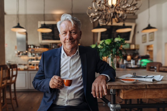 Portrait of senior businessman drinking espresso in a cafe