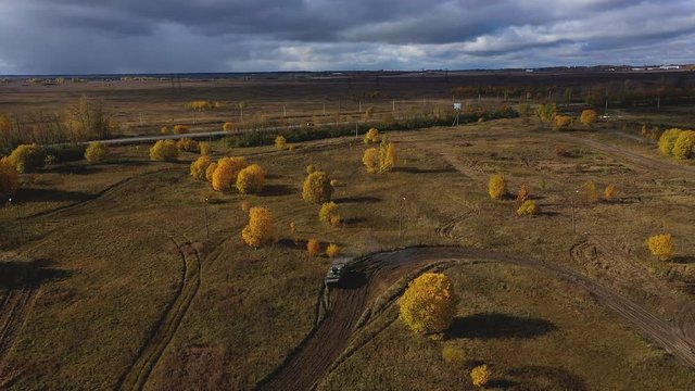 Armoured personnel carrier goes on the field. APC. Aerial video. Drone video. Autumn yellow trees and blue sky. Military trainings