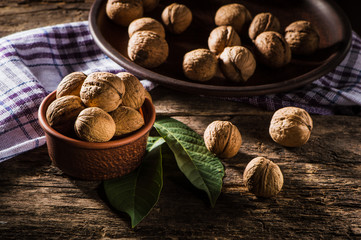 Whole walnuts on a plate.Whole walnuts on rustic old wooden table.Trace elements zinc, magnesium, healthy food.