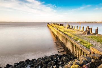 Fototapeta premium Sunset in England, rocky Portishead coast line in long exposure capture.