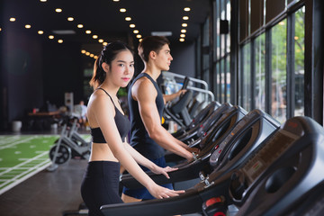 Fototapeta na wymiar Healthy woman and man with sportswear running training on exercise at gym sport, bodybuilding, lifestyle and people concept
