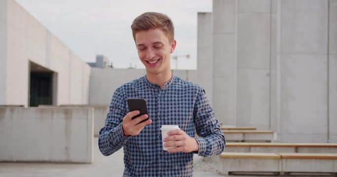 A young man using a phone outdoors.