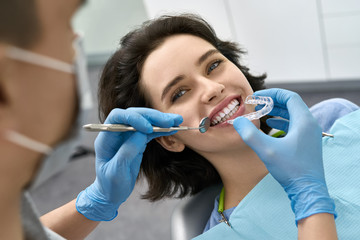 Pretty woman's teeth treatment in dental clinic - 294960351