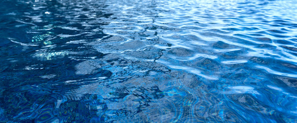 Banner of bright blue ripped water in swimming pool.