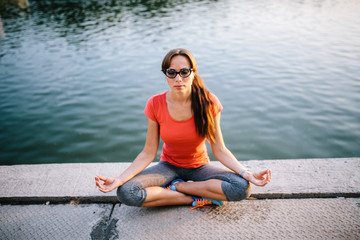 Young beautiful woman practicing yoga outdoor. Relax