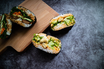 Broccoli onigirazu and tofu onigirazu on a wooden table. Japanese cuisine.