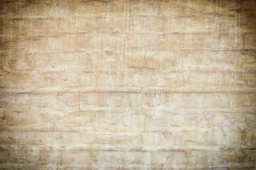 Brick wall painted in light brown paint. Old coating in spots and smudges, photo with vignette. Empty background for layouts and sites.