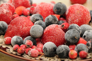 frozen forest fruits strawberry  blueberry on a plate in a group