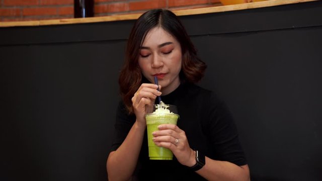 woman drinking green Tea frappe in cafe
