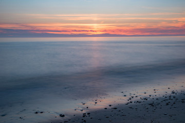 Close up wave on the beach in long exposure during sunset.