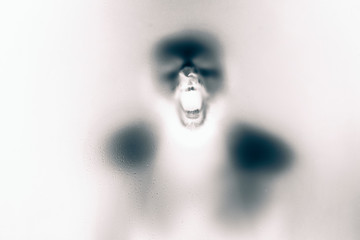 Inversed color version of Creepy man screaming behind the frosted glass.