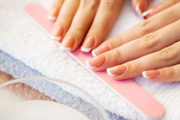Nails care. Beautiful woman's nails with french manicure, in beauty studio