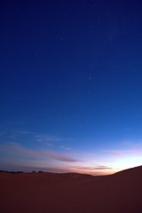 Nightfall on the desert. The first stars can be seen in the deep blue sky.