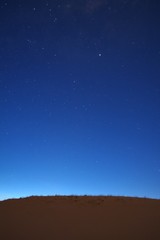 Fototapeta premium Nightfall on the desert. The first stars can be seen in the deep blue sky.