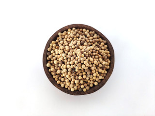 Piper Albi Linn / White Pepper (known as Lada or Merica Putih in Indonesia) on a wooden bowl at white background