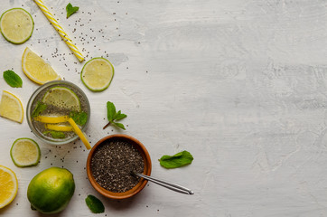 Chia water drink with lemon and mint on cement background