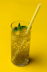 Chia water drink with lemon and mint on colored background