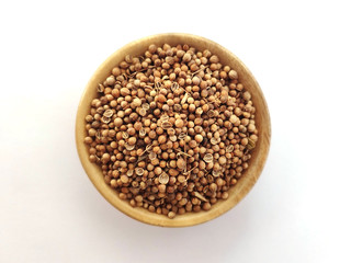 Coriandrum sativum (known as Ketumbar in Indonesia) on a wooden bowl at white background