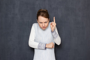 Portrait of funny dissatisfied girl shaking index finger