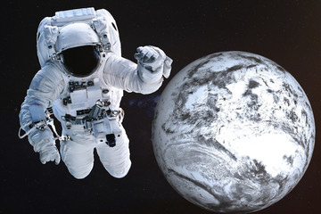 Obraz na płótnie Canvas Giant Astronaut near the Dead frozen Earth planet of Solar system. Science fiction. Elements of the image are furnished by NASA