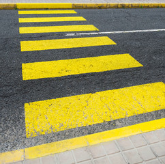 Fototapeta premium Yellow zebra crossing bands in diagonal perspective.