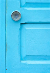 Blue door detail with a knob, close up large detail in vertical framing.