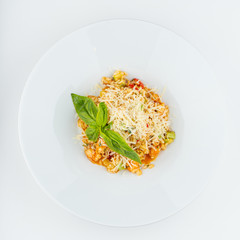 Top view of orange squash vegetables risotto with basil and parmesan cheese isolated on white flat lay