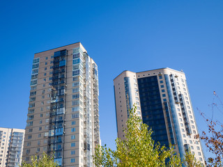 Fototapeta na wymiar Modern residential high-rise buildings on a background of blue sky. Theme of modern geometric architecture and urbanization