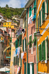 Riomaggiore, Cinque Terre, Italy - August 17, 2019: Colorful houses with wooden shutters, a resort village in a mountainous area near the sea. Street antique lamp