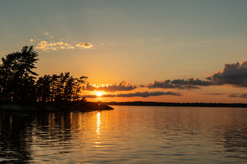 Fototapeta na wymiar Sunset Casts Light Over Rainy Lake