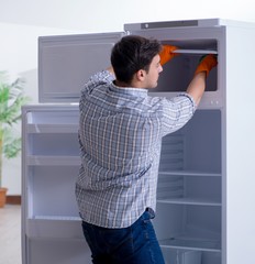 Man cleaning fridge in hygiene concept