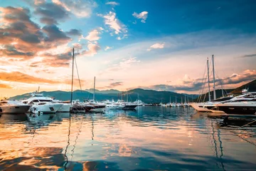 Fotobehang Luxury yachts and motor boats docked in marina Porto Montenegro in Mediterranean sea at sunset. © goncharovaia