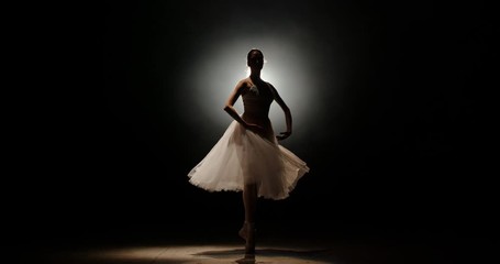 Female ballet dancer performing on spotted stage, douing various movements and pirouettes - arts, success concept 4k footage - Powered by Adobe