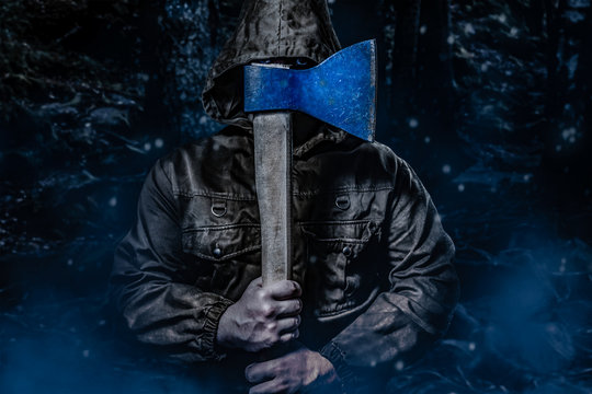 Murderer with an axe in dark woods.