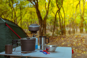 Camping tent with desk and chairs in  forest, сamping cookware set outdoors