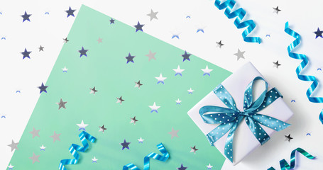 Obraz premium Gift box with confetti and ribbons - overhead view flat lay