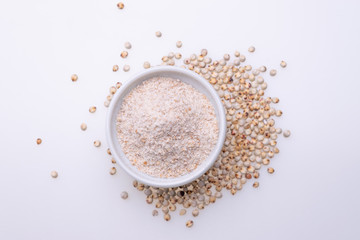 Uncooked raw Sorghum flour (also known as sorgo) in a white bowl, isolated on white background
