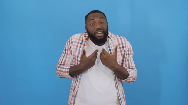Handsome young man doing I do not know reaction, isolated on blue background. 4K