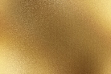 Shiny brushed gold metallic wall with scratched surface, abstract texture background