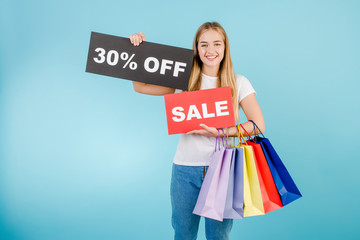 woman with 30% off sale sign and colorful shopping bags isolated over blue