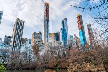 New York City, NY, USA - 25th, December, 2018 - Beautiful Architecture Skyline Buildings view in a cold sunny day in Central Park at the lake near Gapstow Bridge.