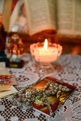 candles on a table, religious background, religious rosary, bobbin lace tablecloth, lace tablecloth, devotional moment with rosary and candle, Christian still life with sacred objects
